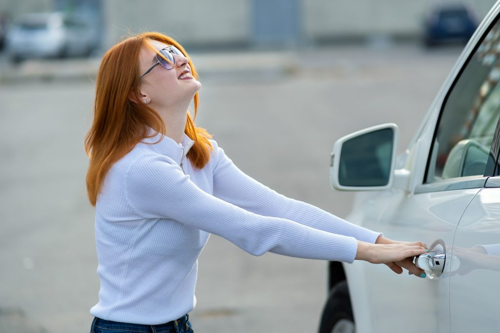 Eine Frau kann ihre Autotür nicht öffnen und benötigt eine Autotüröffnung vom Schlüsseldienst