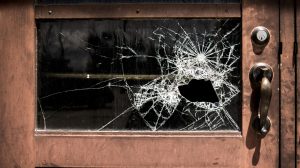 Zerbrochenes Glas einer Eingangstür nach einem Einbruchsversuch